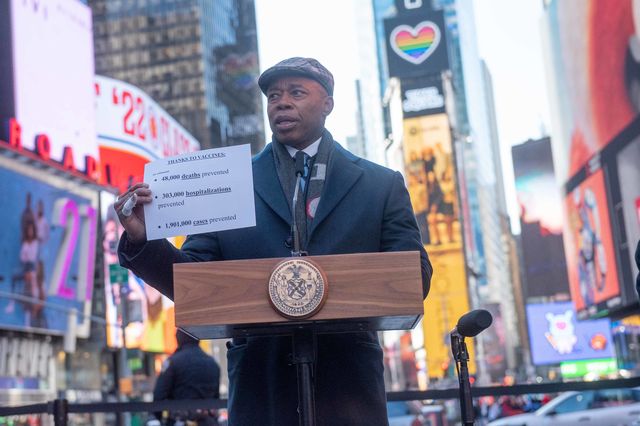 Mayor Eric Adams holds up a white piece of paper at a news conference at Duffy Square in Times Square announcing the end of vaccine mandates for businesses, entertainment and cultural venues.